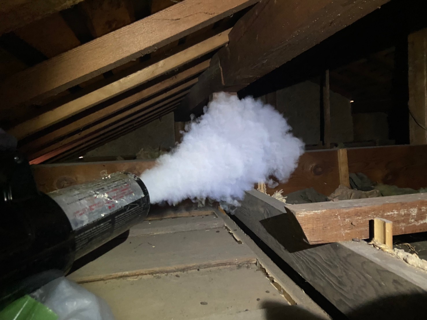 甲賀市の住宅の屋根裏で燻煙剤を散布し、天井裏にいる害獣を外へ追い出している作業の様子