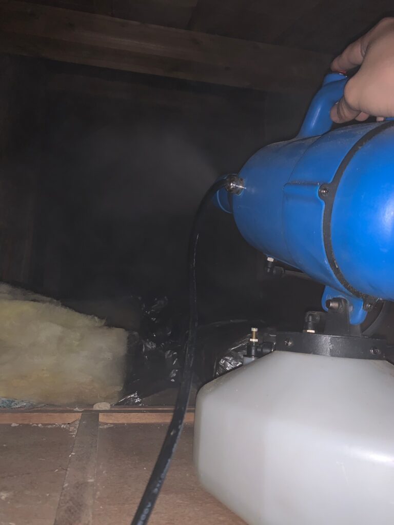 彦根市の戸建ての天井裏で、青い機械を使って殺菌・消毒の薬剤を散布している作業の写真