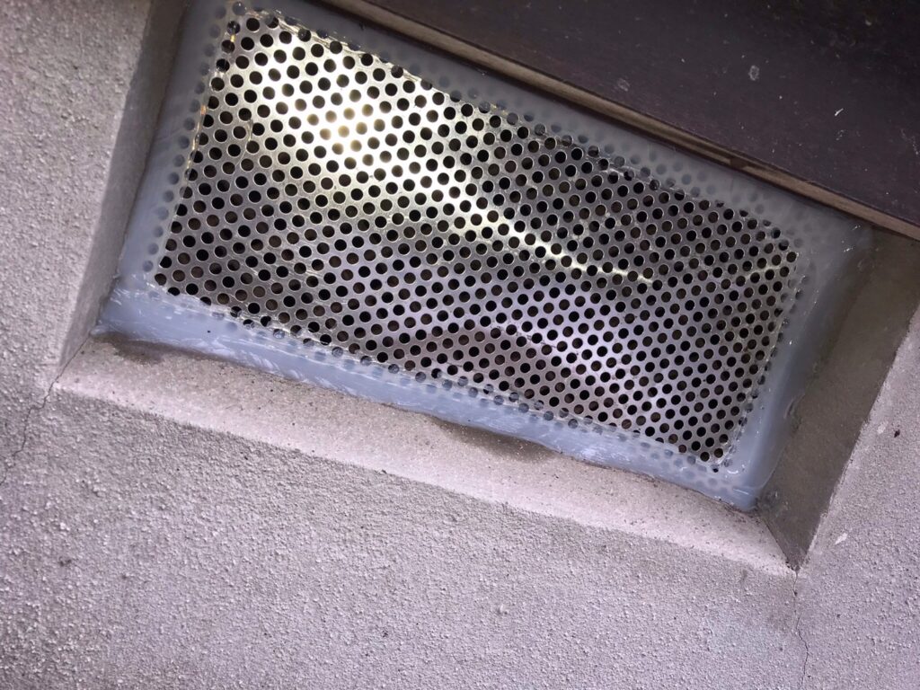 彦根市の戸建てで床下の通風口にパンチングメタルを取り付け、まわりをコーキングで埋めたネズミ駆除の施工写真